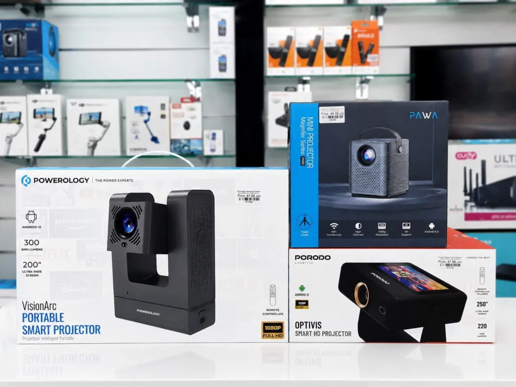 Boxed projectors in Oman on display at Sky Gadgets, including Powerology VisionArc, PAWA Mini Projector, and Porodo Optivis Smart HD Projector