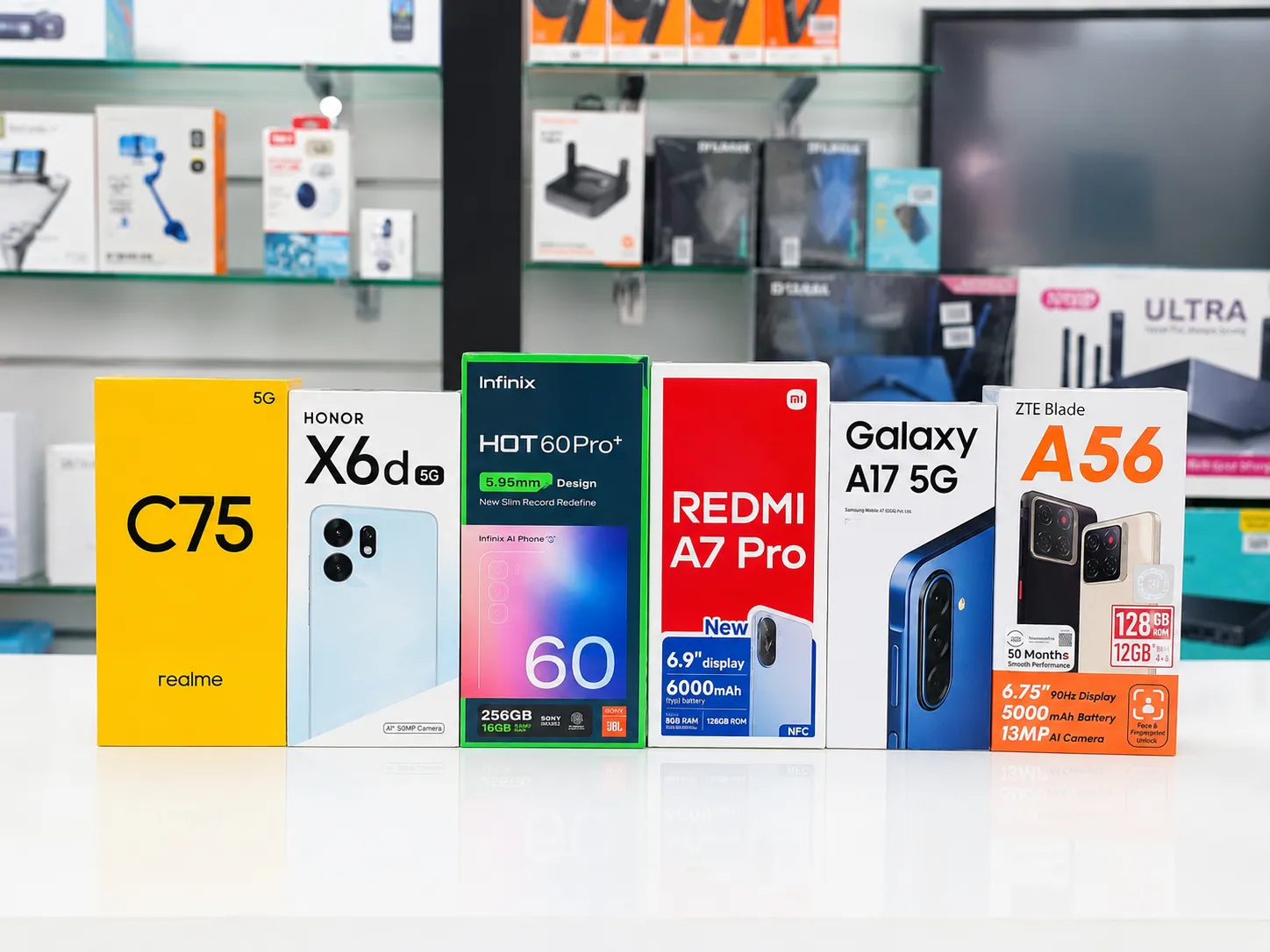 Boxed mobile phones in Oman on display at Sky Gadgets, including realme C75, Honor X6d, Infinix Hot 60 Pro+, Redmi A7 Pro, Galaxy A17 5G, and ZTE Blade A56