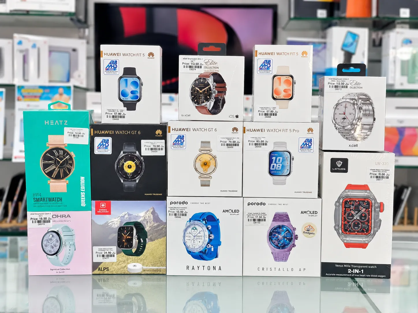 Boxed smartwatches in Oman on display at Sky Gadgets, including Huawei Watch Fit 5, Huawei Watch GT 6, xCell Elite Collection, and Porodo AMOLED smartwatches
